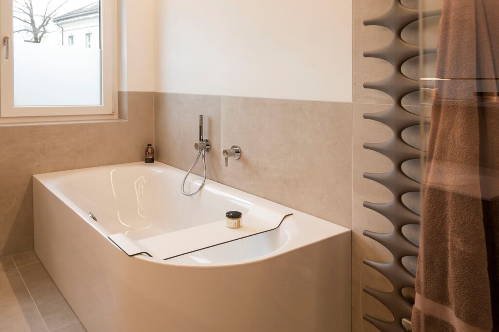 Badewanne mit Fliesenverkleidung und Designheizkörper
