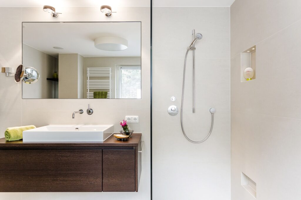 Badezimmer mit Holz-Waschtisch, Spiegel und begehbarer Dusche