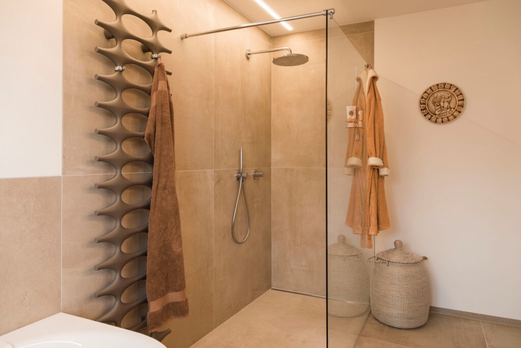 Bodengleiche Walk-in-Dusche mit Glaswand und warmen Fliesentönen